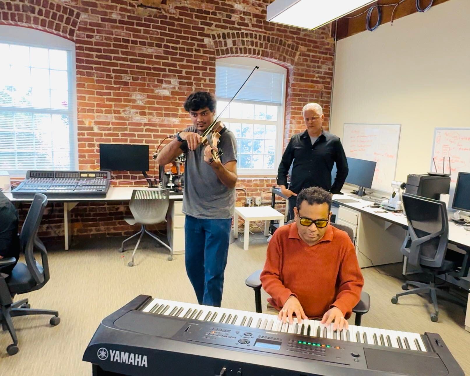 Playing violin in the lab while a visiting musician plays the keyboard