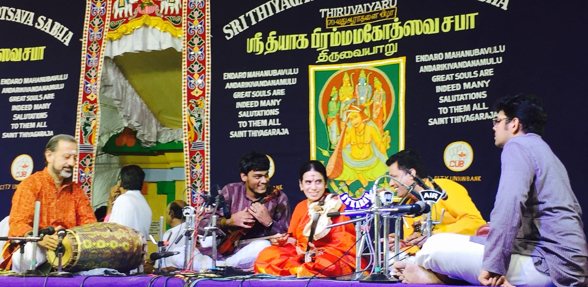 Playing in a violin ensemble at the Thyagaraja Aradhana in Thiruvaiyaru, beneath a portrait of Saint Thyagaraja