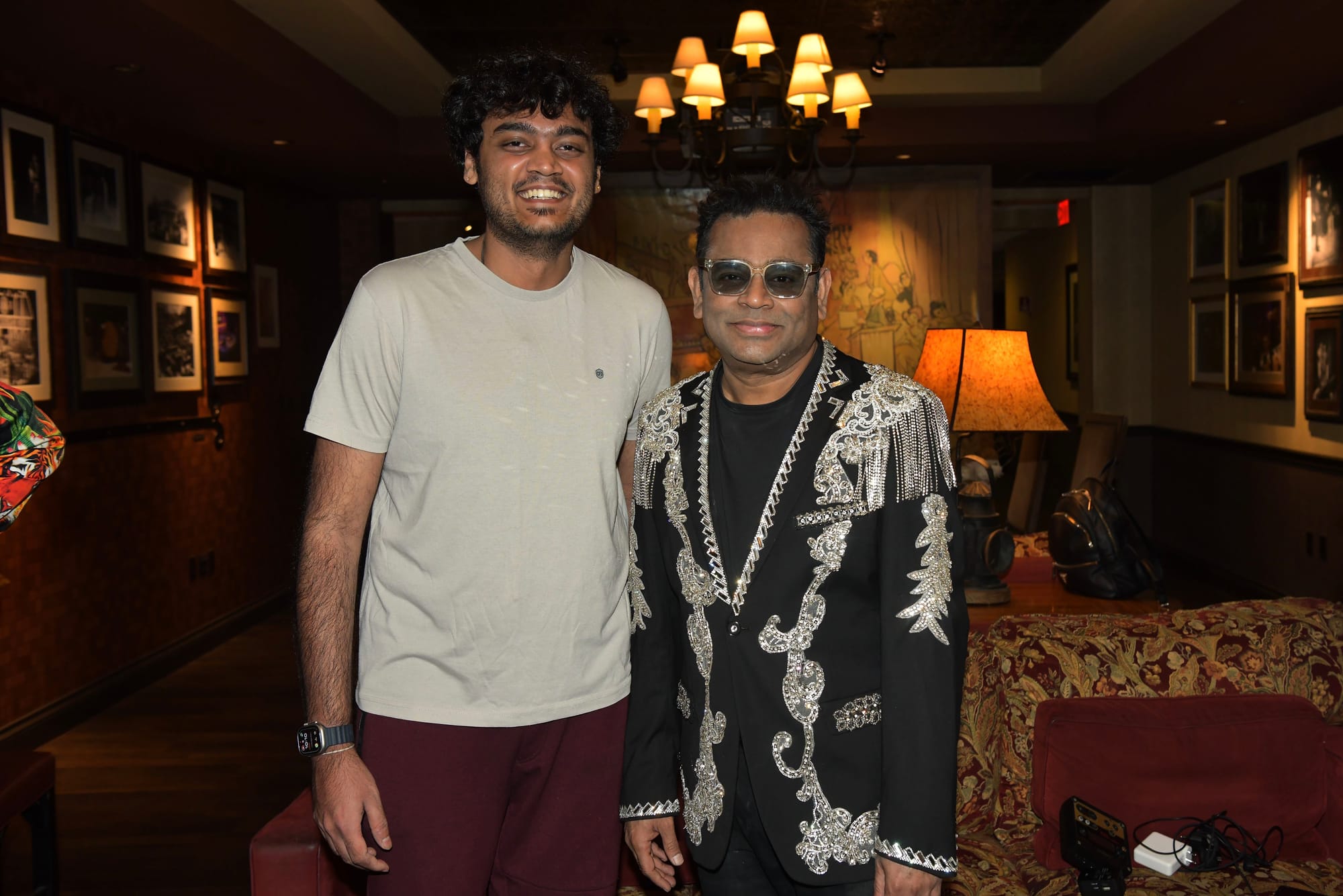 With a guest in an embroidered black jacket, in a wood-panelled room